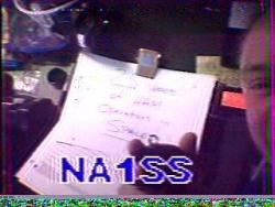 Mike Fincke showing the sign that reads "25 Years of Ham Operations in Space".